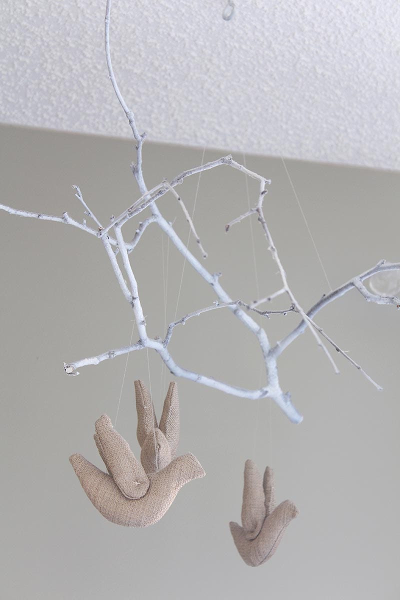 DIY white tree branch mobile with beige birds.