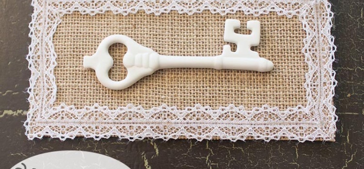 A white porcelain key, burlap backing and lace all come together in this vintage-inspired mounted key artwork. A super easy DIY for a super cute decor item!