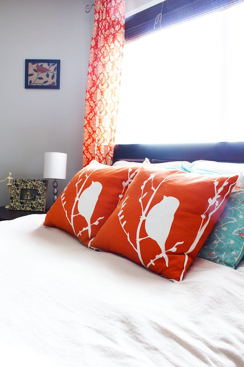 A blue and orange master bedroom with damask curtains and bird accents.