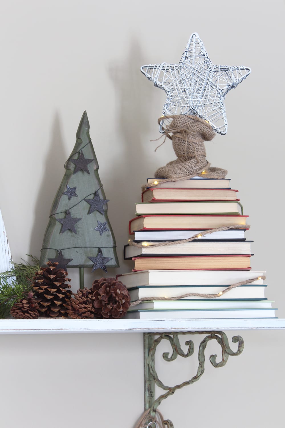 Nature inspired holiday decor alongside a Christmas tree made from a stack of books. For the book nerd in all of us!