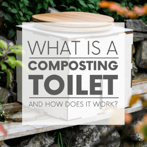 A white compost toilet in the forest with the words 
