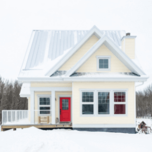 Yellow house with a red door in winter.