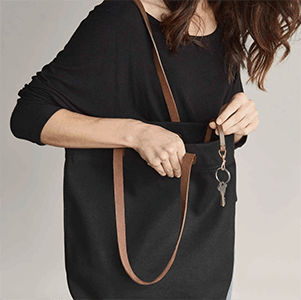 Closeup of a woman holding a black canvas bag.