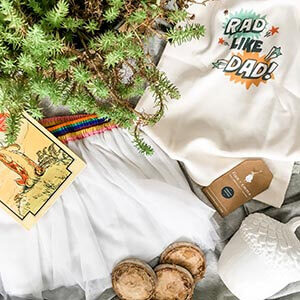 Various baby items on a grey background along with a plant. Click to visit post.