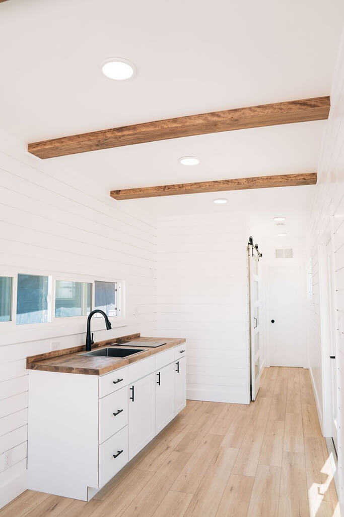 A shipping container home interior with white shiplap walls.