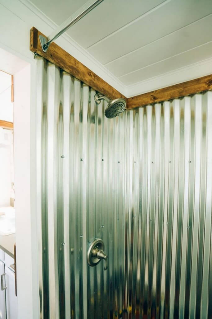 A shower with corrugated metal wall panels.