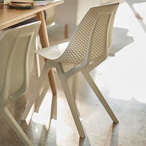 Two white chairs by a wooden table.