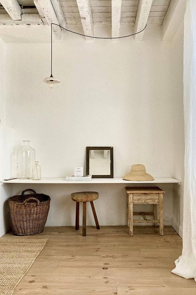 A white floating desk with rustic accessories.