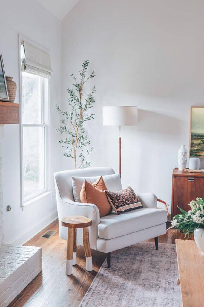 A rustic minimalist living room with a white armchair.