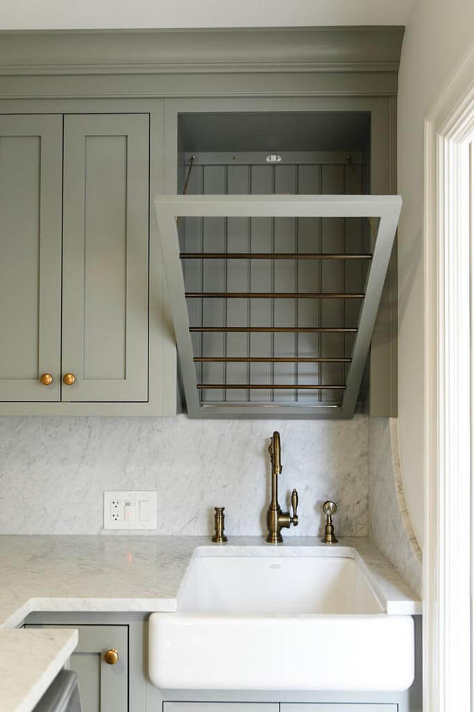 A stylish laundry room with a green cabinets.