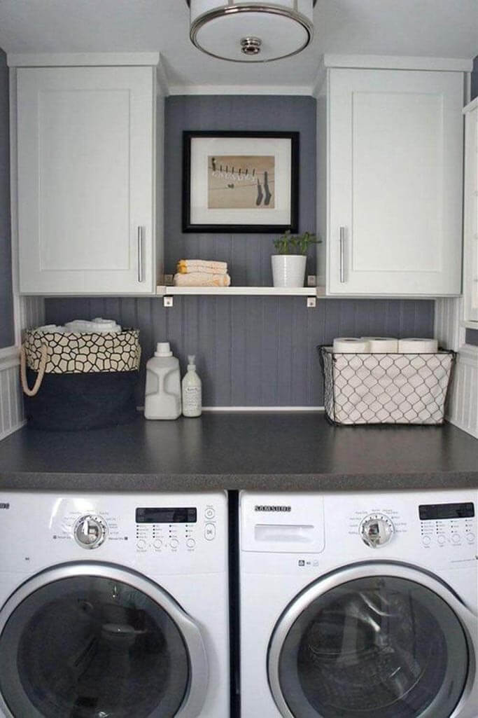 A laundry room with a grey feature wall and a white washer and dryer.