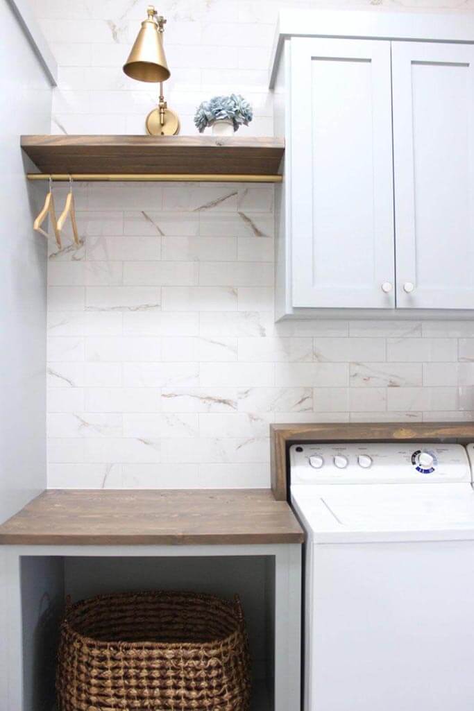 A laundry room with a tile feature wall and a white washer and dryer.
