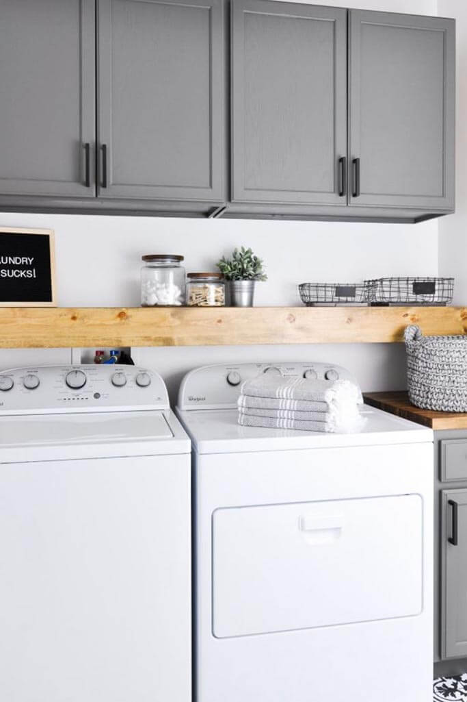 A laundry room with a grey cabinets and a white washer and dryer.