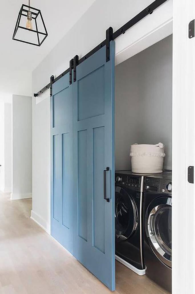 A laundry room behind a sliding blue barn door.