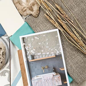 Various paint samples, fabric samples and coastal items with a photo of a coastal bathroom sitting on top.