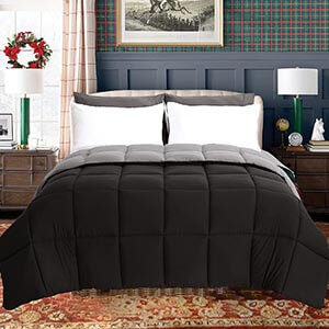 A black comforter in a room with plaid wallpaper.