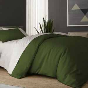 A bedroom with forest green bedding.