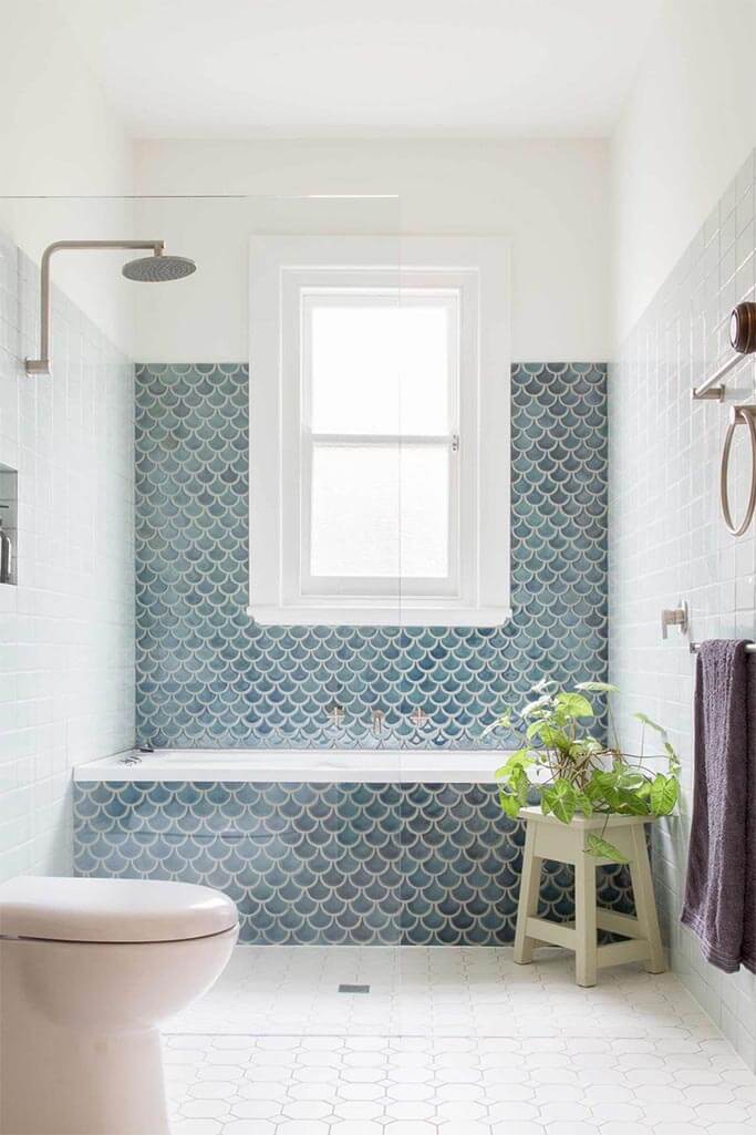 A bright bathroom with blue shower tile.