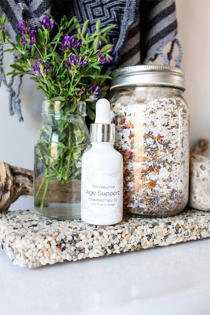Closeup of personal care items and flowers in a bathroom.