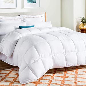 A white duvet on a bed in a room with a bright orange rug.