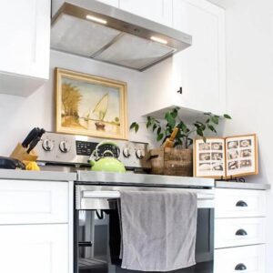 A bright kitchen with a stainless steel stove and rustic accessories.