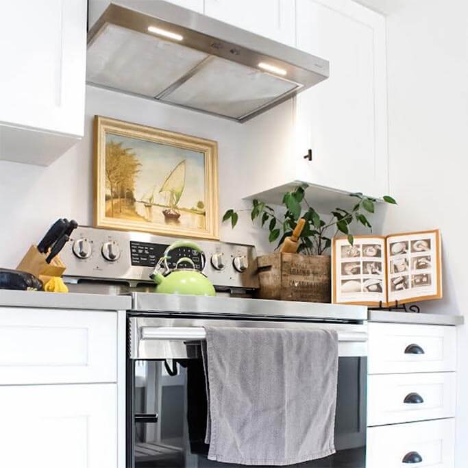 A bright kitchen with a stainless steel stove and rustic accessories.