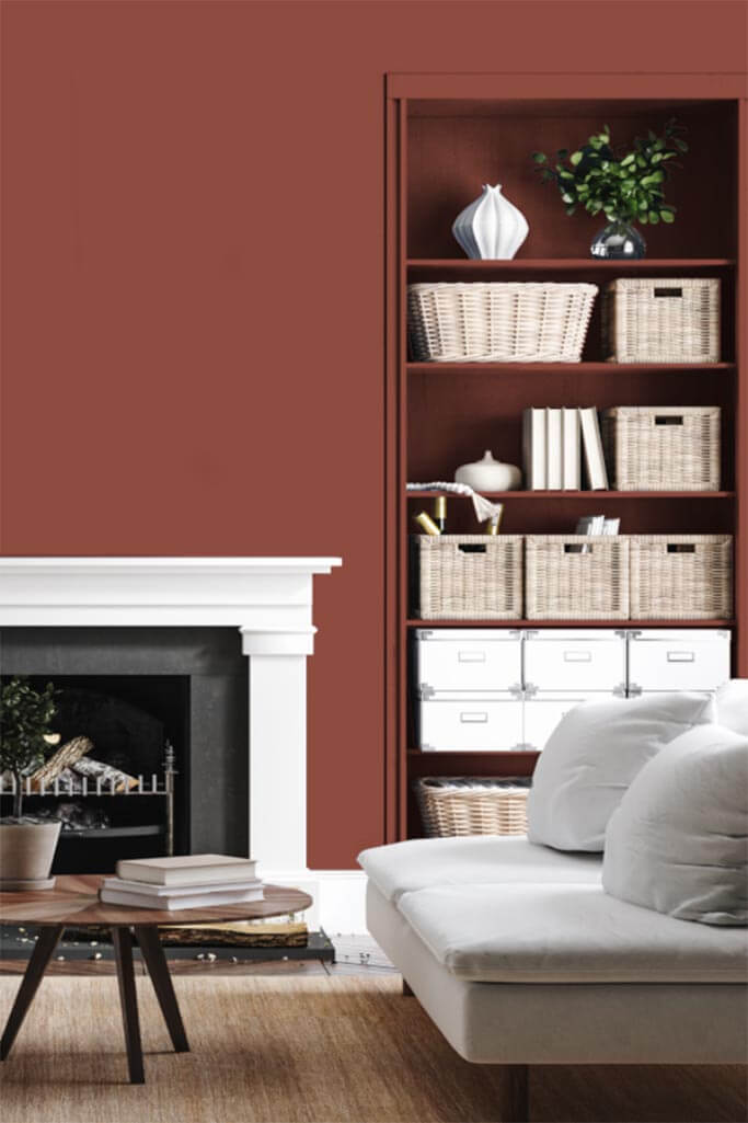 Living room with dark red walls and a white couch.