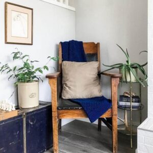 A wooden chair sitting in a corner with dark blue and gold accents.