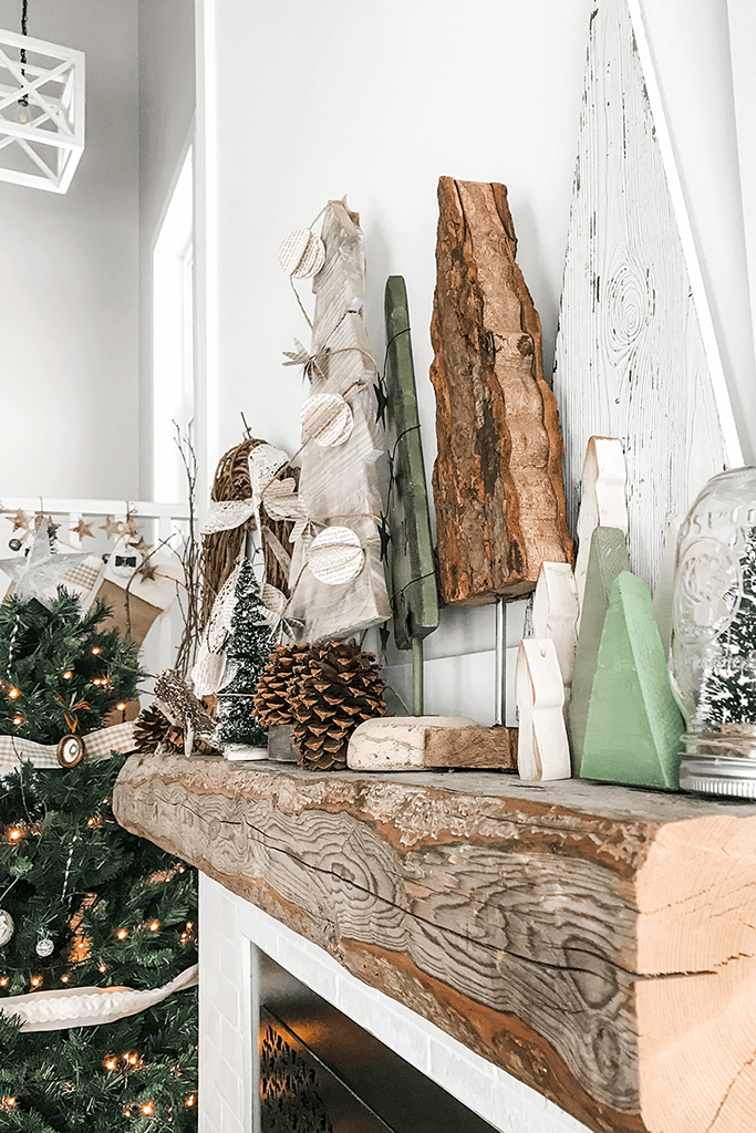 A wood mantel decorated with rustic holiday decor.