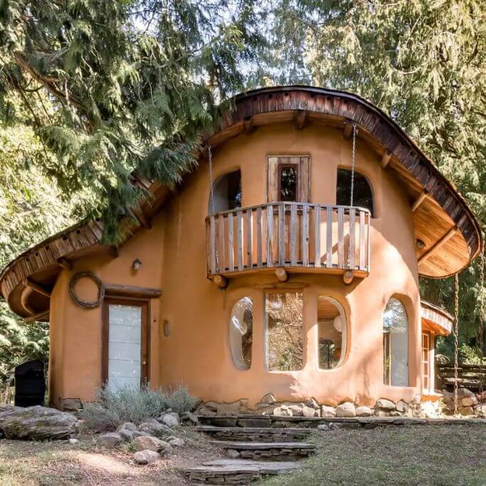 Exterior of a light orange-brown cob home.