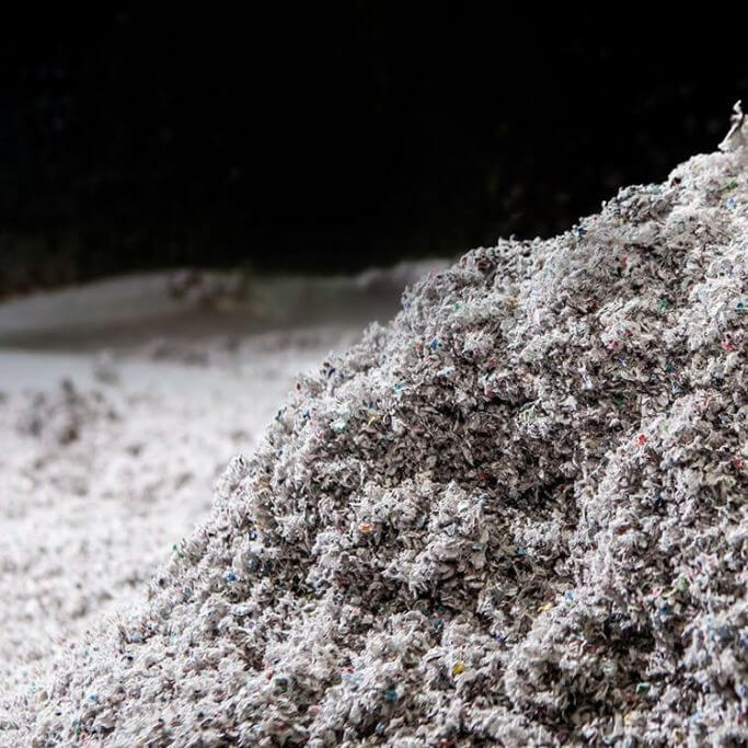 Loose cellulose insulation on a black background.