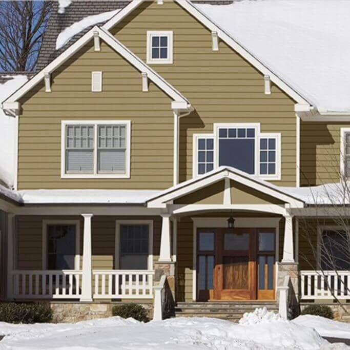 A traditional-style home with olive coloured vinyl siding.