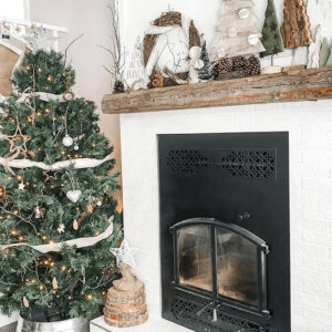 A living room decorated with a Christmas tree and rustic ornaments.