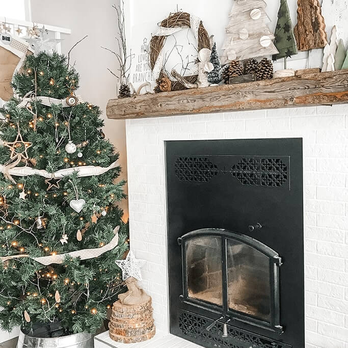 A living room decorated with a Christmas tree and rustic ornaments.