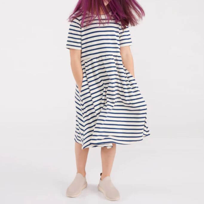 A child wearing a white and navy striped dress.