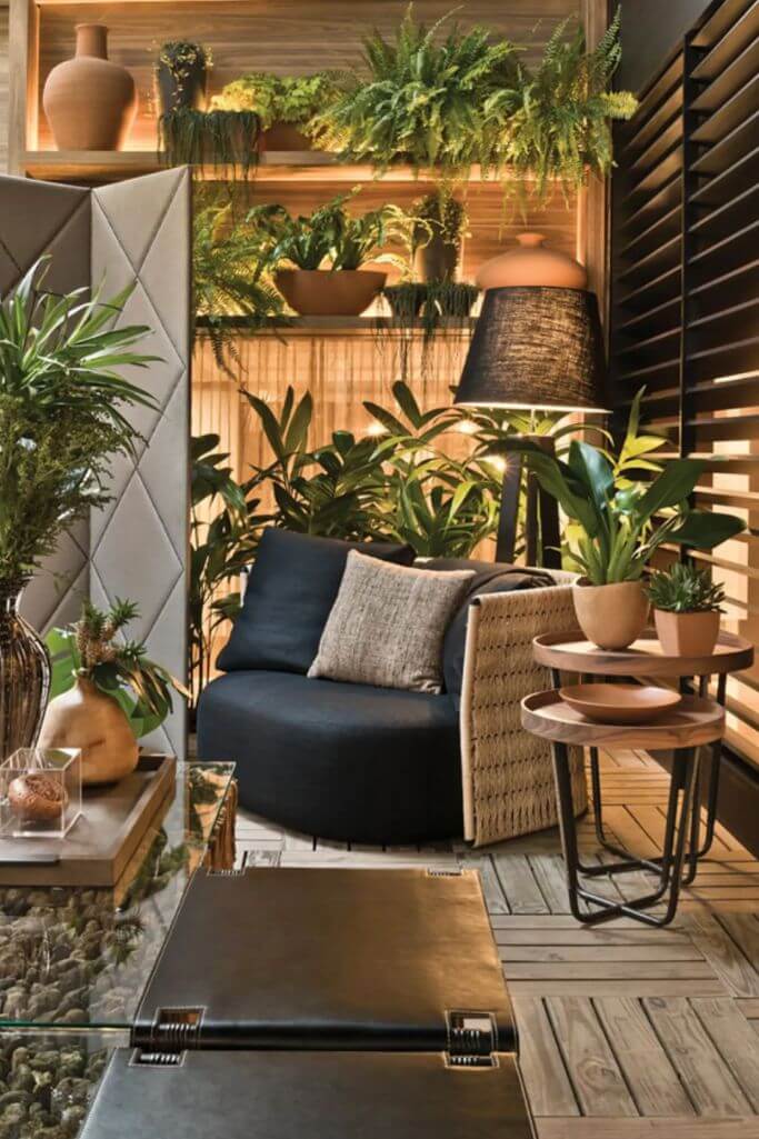A plant filled indoor garden room with earth toned furniture and decor.