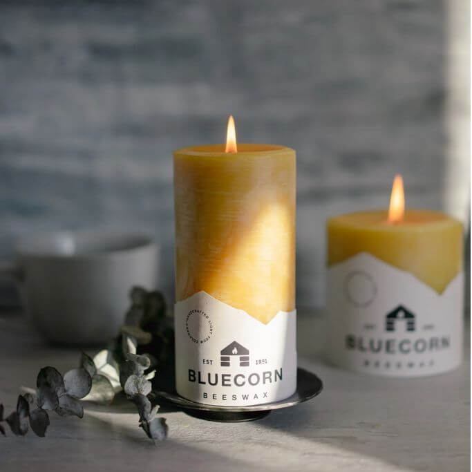 Yellow pillar candles with a label on them that reads bluecorn.