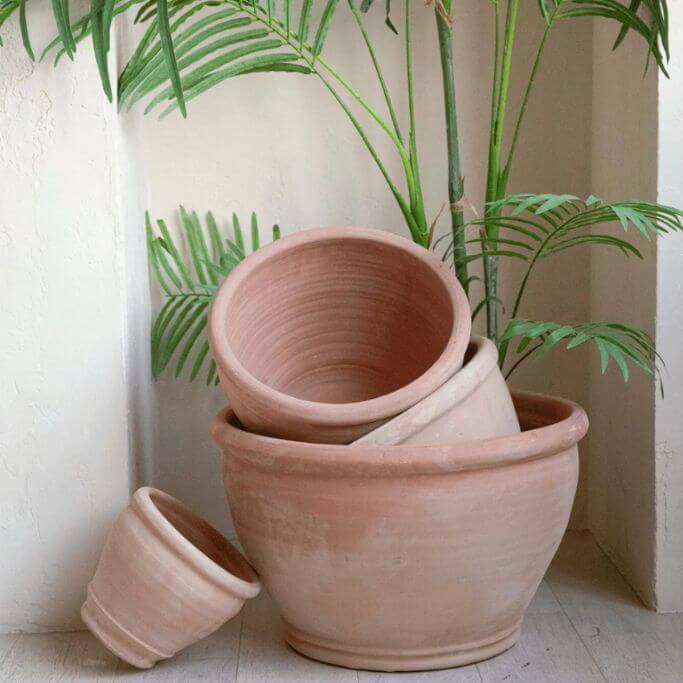 A stack of terracotta pots on an outdoor patio.