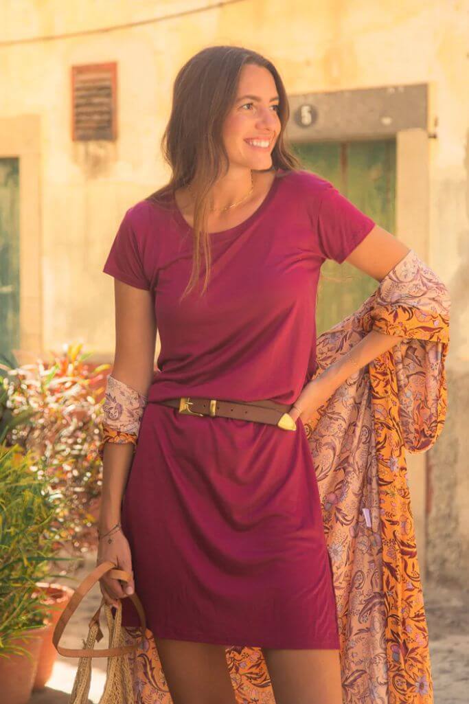 A woman wearing a fuchsia dress and a gold belt.