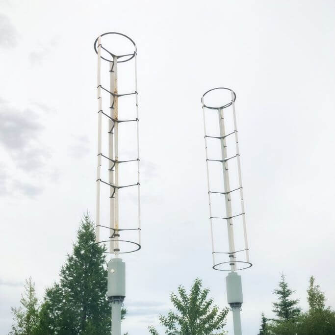 Two wind turbines against a cloudy sky.