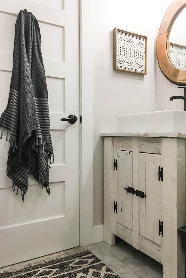 A rustic bathroom with wood and black accents.